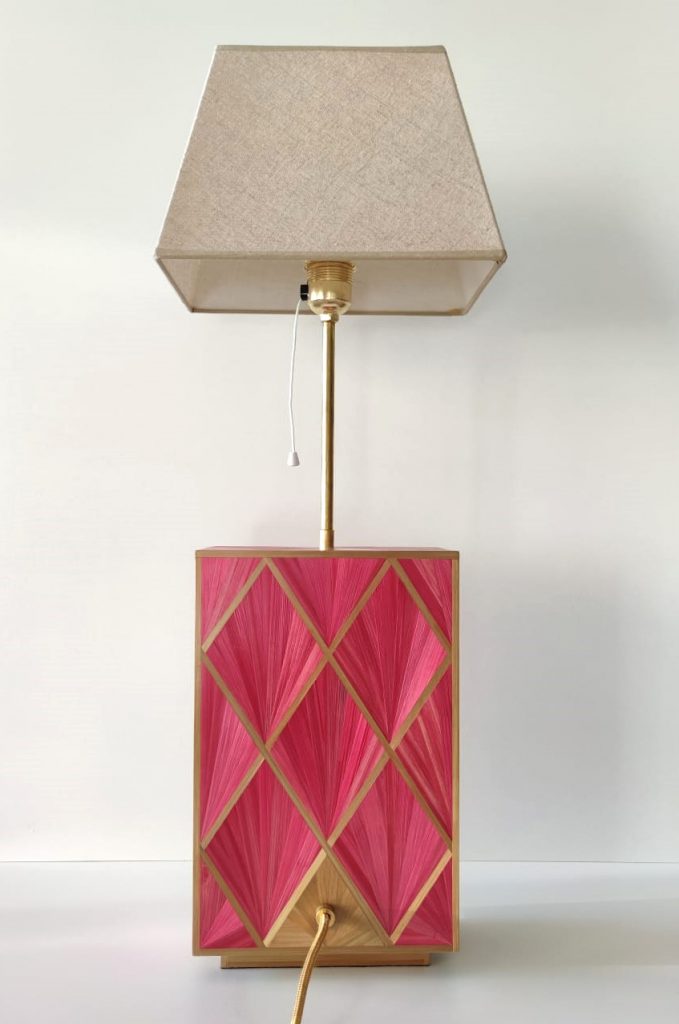 Cuerpo de lámpara con motivos geométricos, realizado con paja de centeno rosa y dorada. 