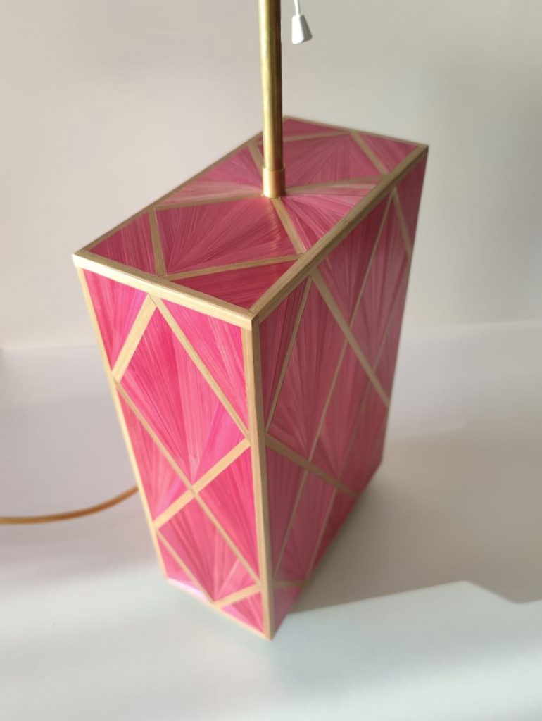 Detalle de cuerpo de lámpara con motivos geométricos, en paja de centeno rosa y dorada.